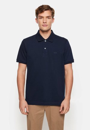Navy-Polohemd aus Baumwolle, mit klassischem Kragen, kurzen Ärmeln und einer Knopfleiste mit drei Knöpfen, sowie einem kleinen Logodetail auf der Brust.
