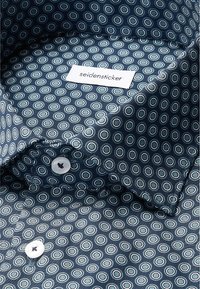 Interno della camicia blu scuro con un motivo geometrico di cerchi blu chiaro e bianchi. Presenta un'etichetta bianca con la scritta "seidensticker" e chiusure a bottoni.