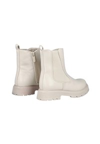 Botas de tobillo color crema con paneles elásticos en los laterales y una cremallera en la parte posterior. Suela de goma texturizada y detalle de costura alrededor de los bordes.