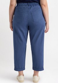 Denim broek met een elastische tailleband, opgerolde mouwen en twee achterzakken, in een middelblauwe kleur met een gladde textuur.