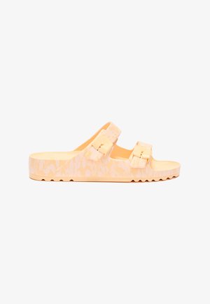 Lys ferskenfarvet slip-in sandal med to justerbare remme med spænder og tekstureret sål, designet til afslappet brug.