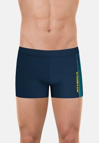 Shorts de bain bleu marine avec une coupe ajustée, arborant un logo jaune et un motif vertical texturé turquoise sur le côté.