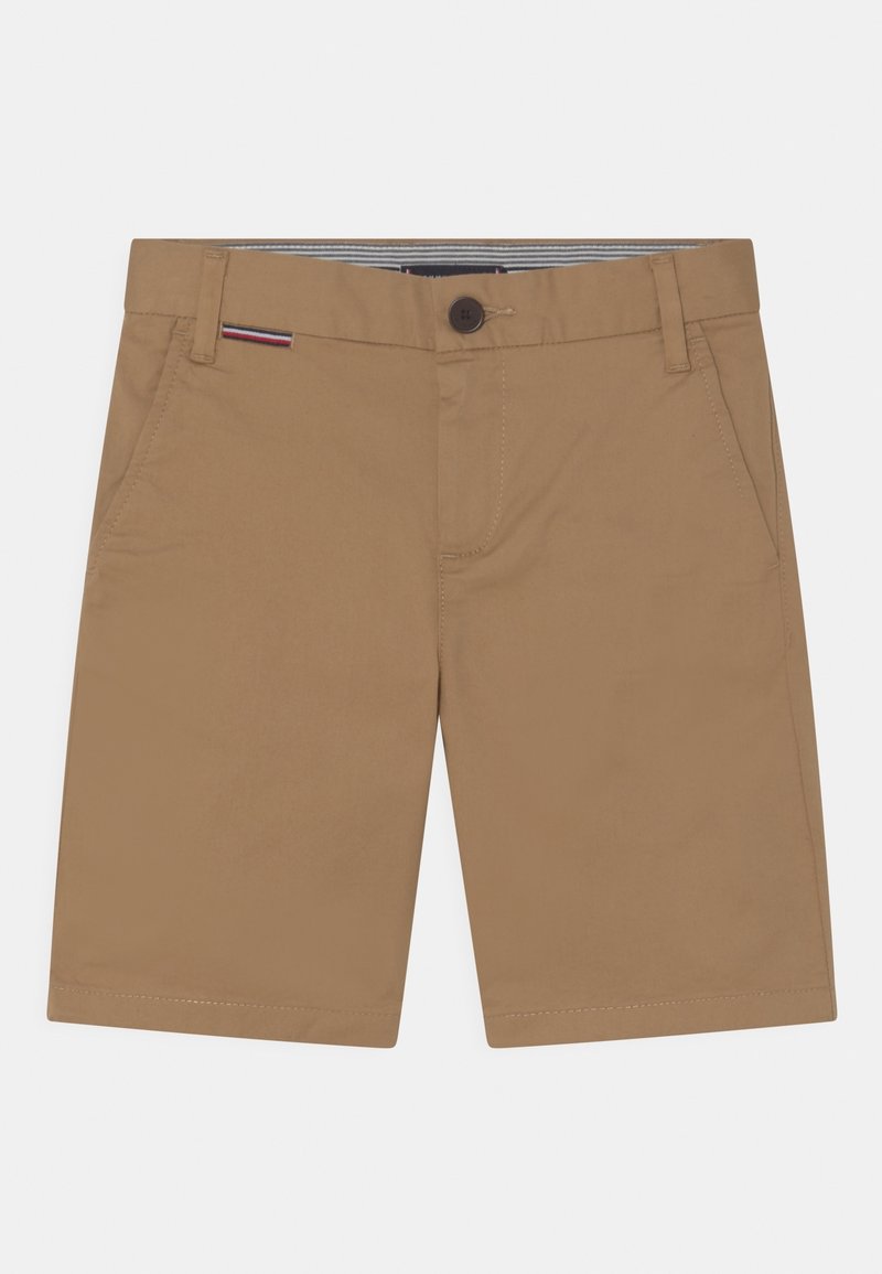 Shorts couleur beige jusqu'aux genoux avec poches avant, passants pour ceinture, fermeture par bouton et une petite étiquette rayée rouge, blanche et noire près de la ceinture.