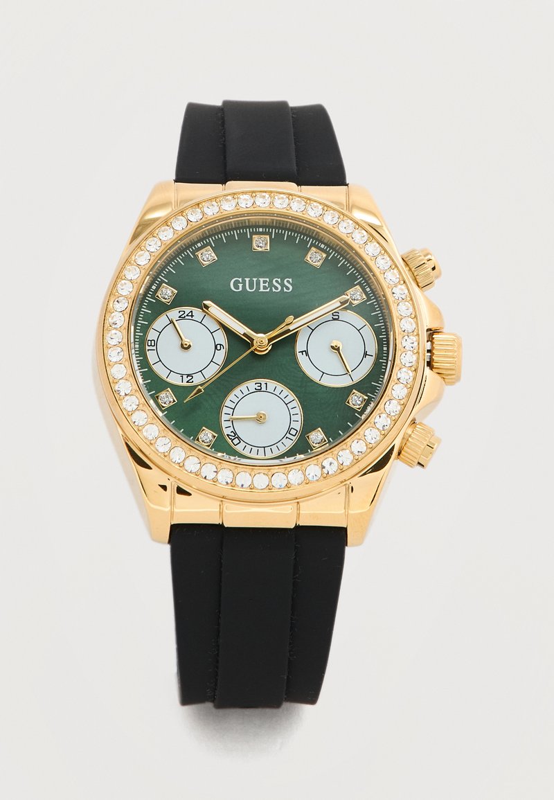 Ρολόι χειρός Guess σε απόχρωση χρυσού με πράσινο καντράν, τρεις υποκαντράν, κρυστάλλινους δείκτες και μαύρο λουράκι σιλικόνης.