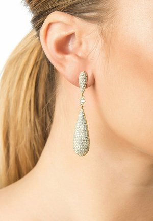Gold-colored teardrop earrings featuring a textured, shimmering surface with a smooth upper section and a clear gemstone accent.