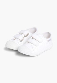Valged kanvas kingad kahekordsete Velcro rihmadega, kummist talla, ümar toe ja tekstuuriga kangaga. Pole nähtavaid mustreid ega aksessuaare.