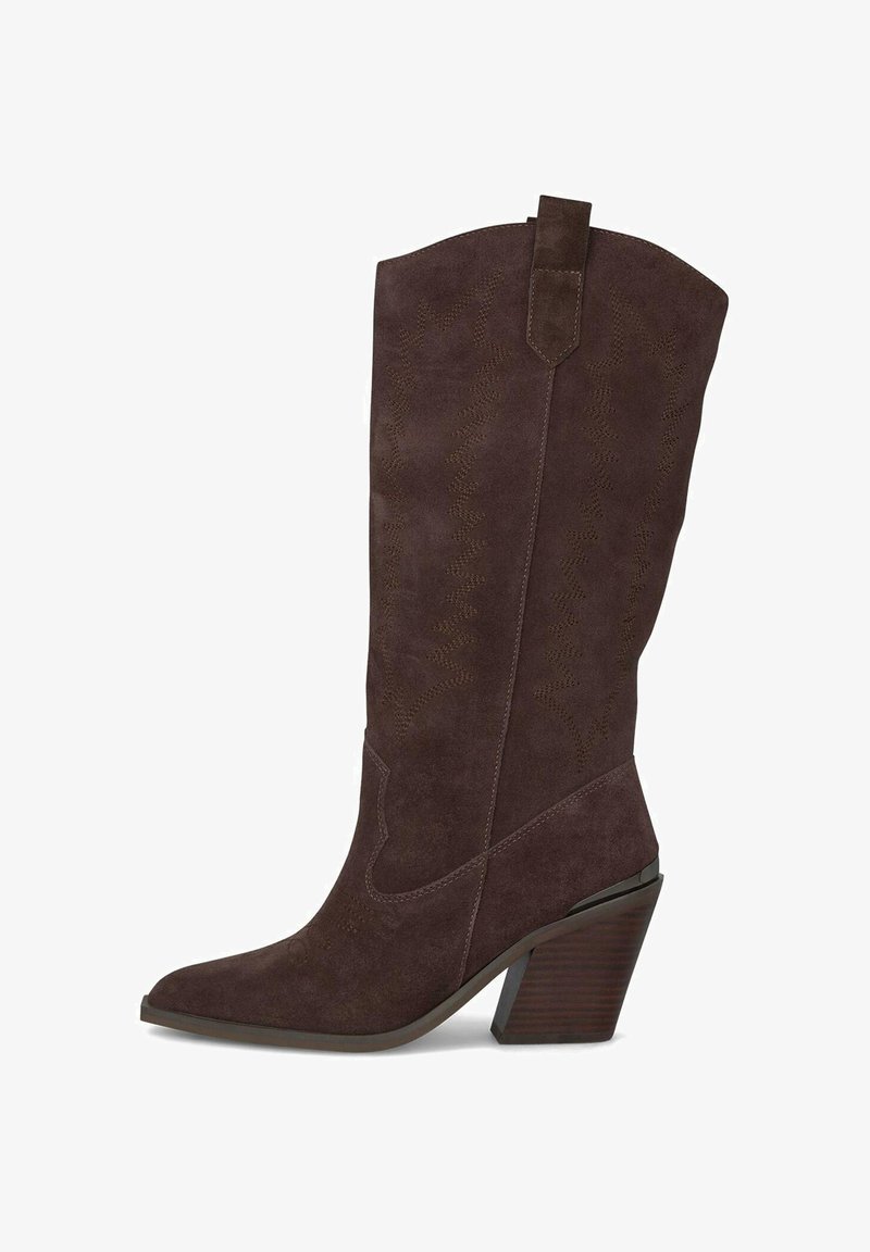 Botas de cowboy de ante marrón con puntera puntiaguda, costuras decorativas y un tacón apilado. Cuenta con una lengüeta para facilitar su puesta.