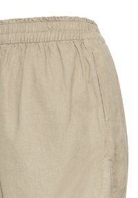 Pantalon en lin beige avec ceinture élastique et couture visible des poches latérales sur fond blanc