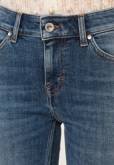 Jeans aus Denim in mittelblau mit einem klassischen Fünf-Taschen-Design, ausgestattet mit kontrastierendem orangefarbenen Nähten und einem silbernen Knopfverschluss.