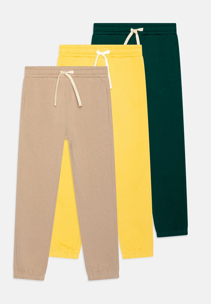Three pairs of sweatpants: beige, yellow, and dark green. Each has an elastic waistband with drawstring and tapered legs. Soft cotton material.