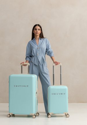 Aqua harde koffer set met glanzende afwerking, zilver beslag en witte wielbases. Bevat een grotere en een kleinere koffer met logo.