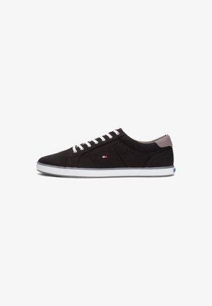 Czarny niski sneaker z białymi sznurowadłami, białą podeszwą, szarą zakładką na pięcie oraz małym logo w kolorach czerwonym, białym i niebieskim po boku.
