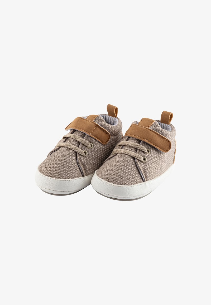 Light brown fabric shoes with a textured finish, white rubber soles, and brown leather accents. Features laces and a velcro strap for closure.