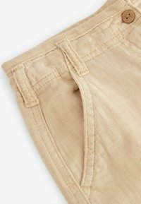 Khaki Leinen-Shorts mit strukturiertem Stoff, sichtbaren Nähten, einem Bund mit Knopf und schrägen Seitentaschen.