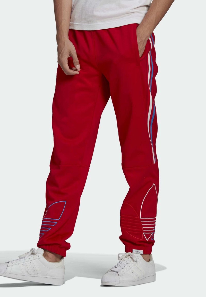Red sweatpants with white and blue side stripes, elastic waistband, side pockets, and blue embroidered logo detail at the hem.