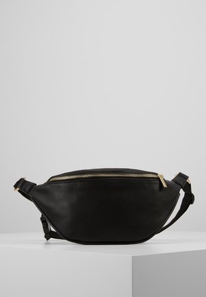 Sort læder bæltetaske med en buet form, guld lynlås og justerbar rem. Glat overflade og minimalistisk design.