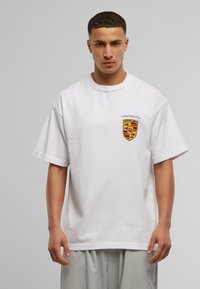 Hvid bomulds t-shirt med rund hals, korte ærmer og et lille multicolor-logo på venstre brystområde.