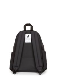 Mochila negra con correas de hombro acolchadas, un asa superior, una etiqueta con un logo de corona y dos bolsillos laterales. El material parece duradero.