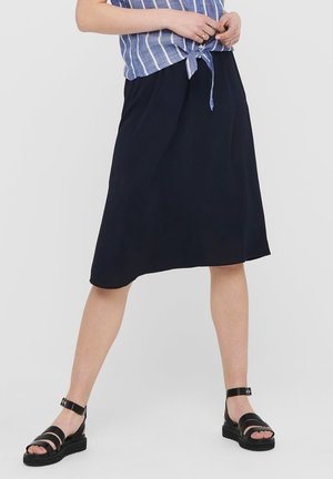 Granatowa spódnica w linii A z lekkiego materiału, o długości do kolan, z gładką fakturą. W połączeniu z czarnymi sandałami na paski i niebieską bluzką w paski.