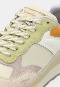 Baskets multicolores avec des lacets crème, des panneaux en daim dans des teintes pastel vert, orange et rose, et le logo "Tamaris" sur la languette.