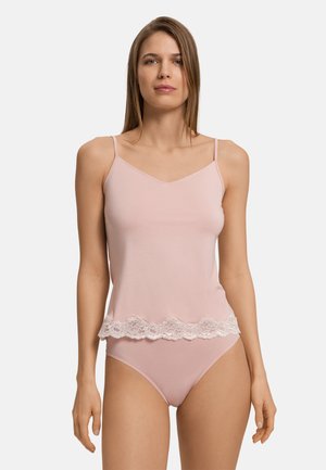 Camisola rosa chiaro con spalline regolabili, caratterizzata da un bordo in pizzo bianco nella parte inferiore. Tessuto morbido, design aderente, texture liscia.