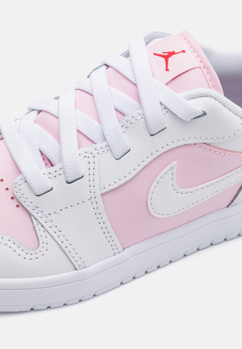 Basket blanche et rose clair en cuir lisse, avec des lacets blancs, un accent logo rouge et des détails cousus.