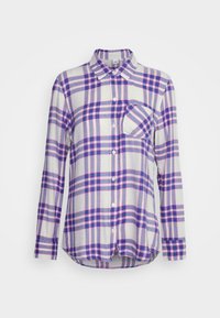 Camicia con bottoni in un leggero tessuto di flanella, con una base bianca e motivo a quadri viola e rosa. Include una tasca sul petto e maniche lunghe.