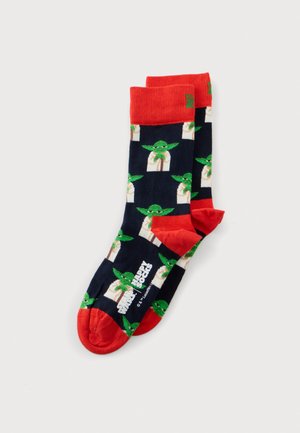 Par de calcetines azul marino con puños y punteras rojos, estampados con personajes verdes de Grogu de Star Wars.