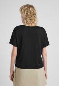 Maglietta nera a maniche corte realizzata in tessuto strutturato. Vestibilità comoda con scollatura rotonda e branding minimale in basso a sinistra.