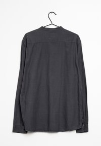 Langsleeve, donkergrijs shirt met een gestructureerd patroon, rechte snit en knoopmanchetten. Hangt aan een zwarte haak tegen een witte achtergrond.