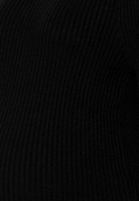 Zwarte ribbel gebreide stof, met een gestructureerd patroon en een aansluitende vorm. Het materiaal is zacht en rekbaar.