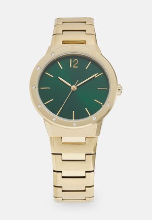 Gold metal watch with a green dial, features gold hour markers, a gold bezel, and crystals at each hour, linked gold bracelet strap.