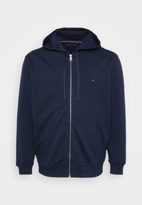 Sweat à zip navy en mélange de coton. Comprend une poche avant, un capuchon avec cordon de serrage et un petit logo sur la poitrine gauche. Texture douce.