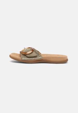 Brun flad sandal med bred olivengrøn rem, stor rund spænde og polstret sål på hvid baggrund.