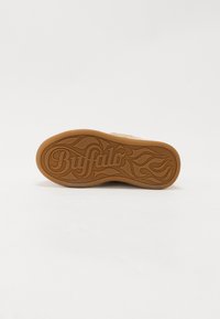 Ruda guma su tekstūru, pasižyminti stilizuota "Buffalo" logotipu ir ugnies raštu; bendras lygus paviršiaus dizainas.