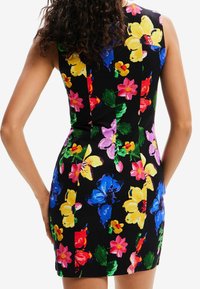 Robe ajustée à motif floral avec une base noire ornée de grandes fleurs colorées en jaune, rose, bleu et vert. Design sans manches avec une texture lisse.