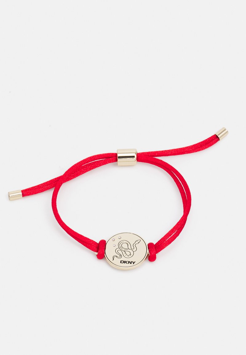 Rød stoffarmbånd med et gullfarget sirkulært charm preget med et slangedesign og "DKNY" logo, sikret med gullaksenter.