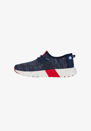 Marineblaue Sportschuh mit einem strukturierten Strickobermaterial, weiß gesprenkelter Sohle und roten Akzenten. Verfügt über ein Schnürdesign und eine flexible Bauweise.
