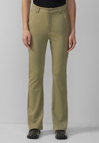 Pantalons beiges ajustés avec une texture lisse, coupe droite et passants de ceinture, dotés de poches latérales pour la fonctionnalité.