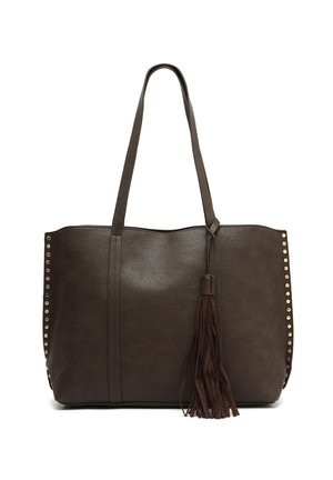 Donkerbruine leren handtas met lange handvaten, gouden studs langs de zijkanten en een hangend kwastje op een witte achtergrond.