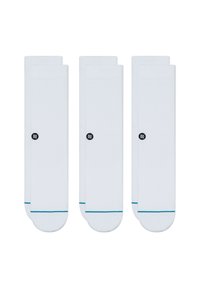 Three pairs of white socks with a ribbed design, featuring a small black logo and a turquoise accent at the toe. Cotton material.