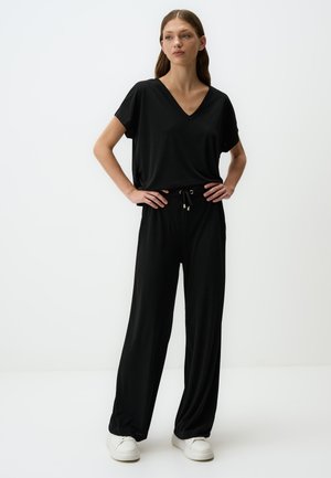 Ensemble noir en deux pièces comprenant un haut à col en V à manches courtes et un pantalon à jambes larges avec une taille élastique et un cordon de serrage. Tissu doux.