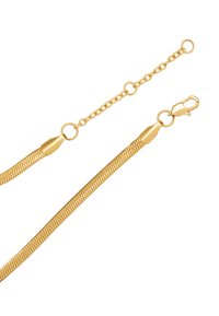 Łańcuch z metalu w złotym odcieniu o eleganckim, elastycznym designie. Wyposażony w zapięcie typu karabińczyk oraz połączony łańcuszek przedłużający o regulowanej długości.