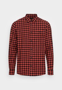 Chemise en flanelle à carreaux rouges et noirs, à manches longues, avec un bouton sur le devant, un col boutonné et une poche sur la poitrine. Texture douce.