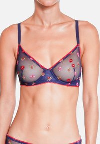 Bralette transparent bleu marine avec broderie florale, bordure festonnée rouge, bretelles ajustables et bonnets triangulaires.