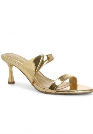 Mule metálico dorado con punta abierta, dos tiras y un tacón fino de altura media sobre un fondo blanco.