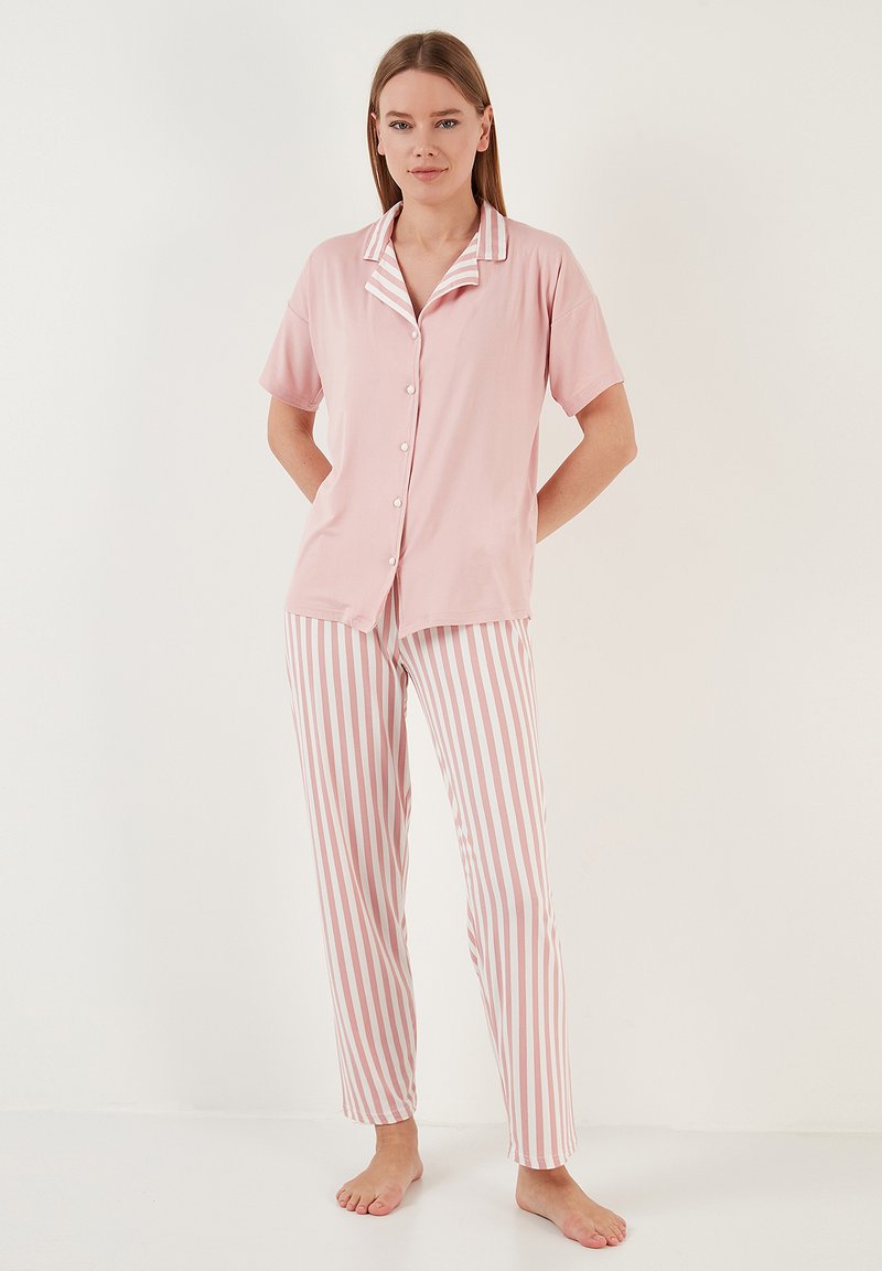 Set de pijamale roz deschis, format dintr-o bluză cu mânecă scurtă și guler alb, care se închide cu nasturi, și pantaloni stripati asortați în roz și alb.