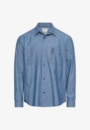 Blauw chambray overhemd met lange mouwen, een knoopsluiting aan de voorkant, twee borstzakken en een klein ritsvakje aan de rechterkant.