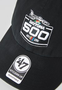 Musta reguleeritav pesapalli kork, millel on tikitud "Daytona 500" logo, mis esitleb ralliauto disaini ja 2025. aasta kuupäeva. Lisatud on "47 Clean Up" silt.