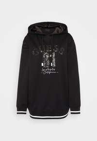 Sudadera negra con un gráfico frontal que presenta texto con lentejuelas. Tiene capucha con cordones y acentos a rayas en los puños y en el dobladillo.
